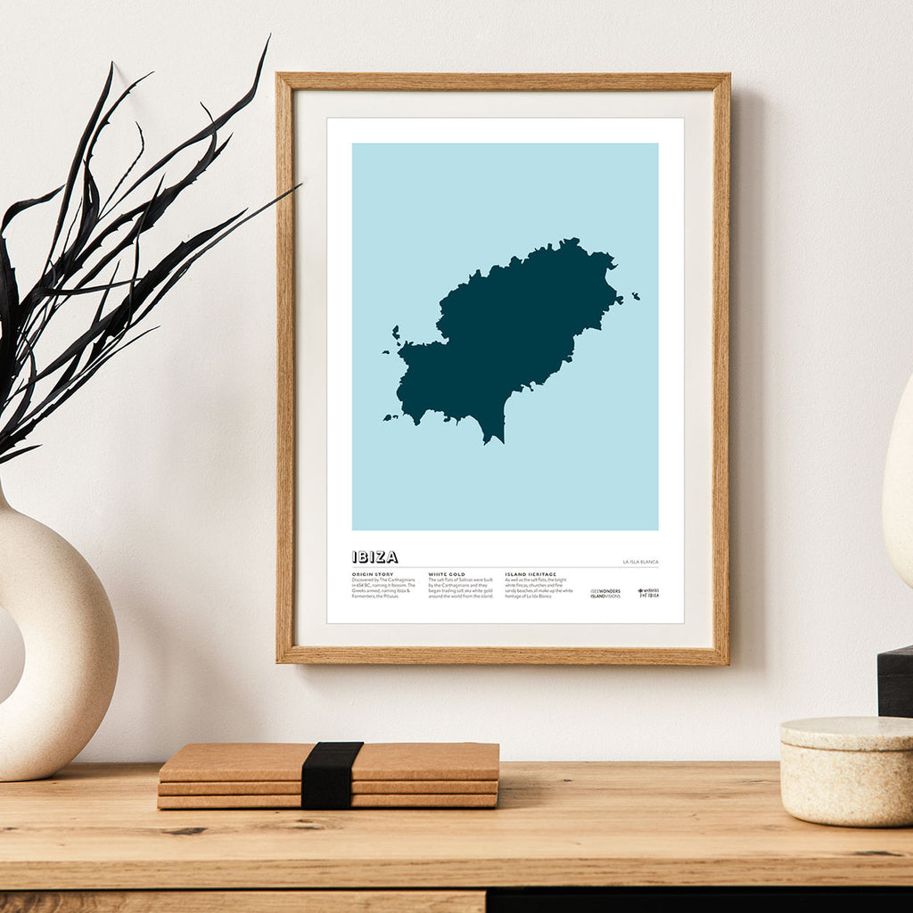 Framed Minimalist art print of Ibiza, graphic design of the island in dark blue from above with a light blue background.