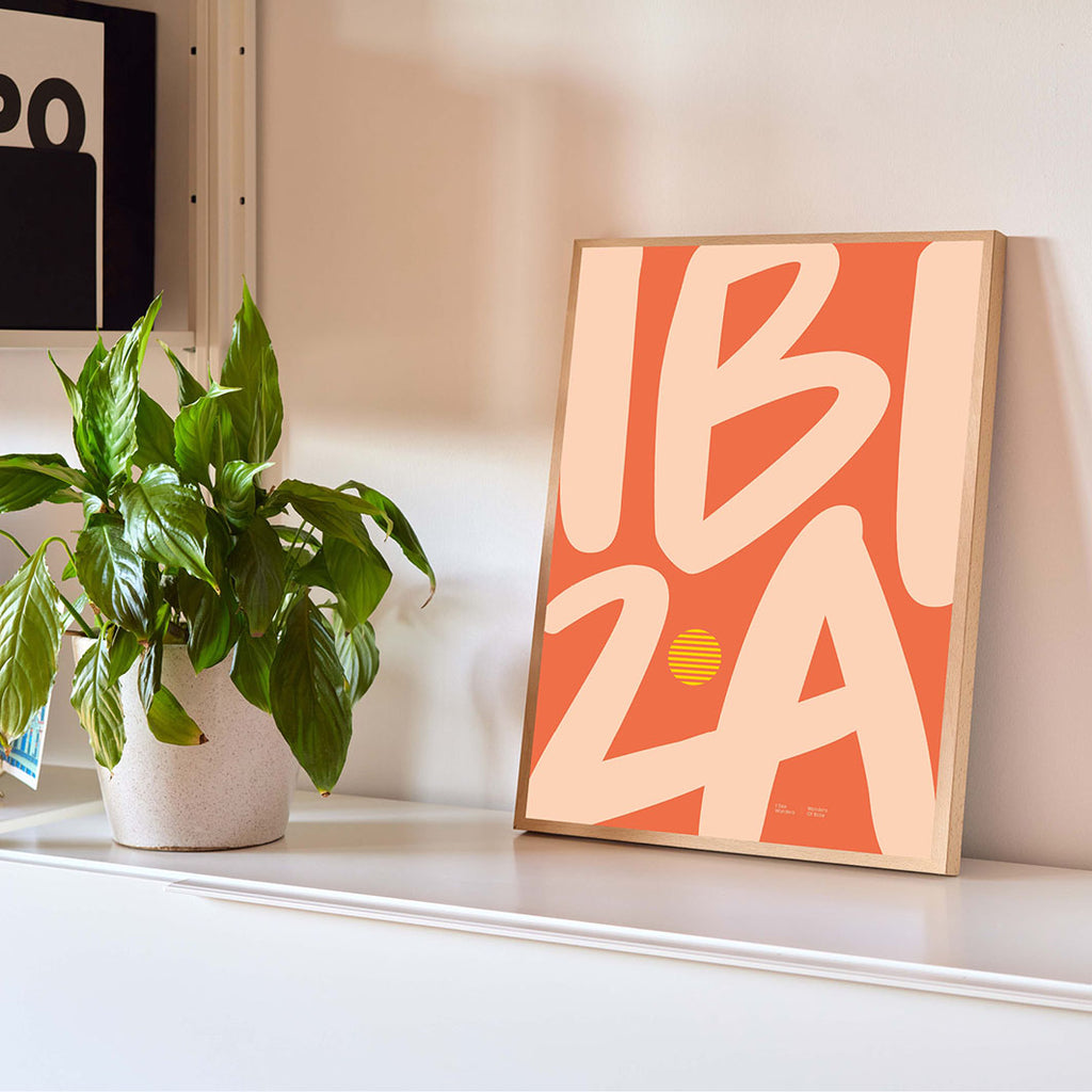 Framed minimal style Ibiza typography print with the word Ibiza in soft orange and sandy colours.
