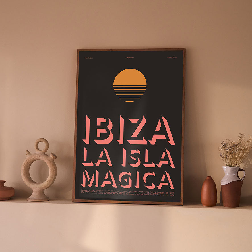 Framed Minimal style Ibiza typography art print with the words Ibiza La Isla Magica in light pink writing on a rich dark background with warm orange sun.