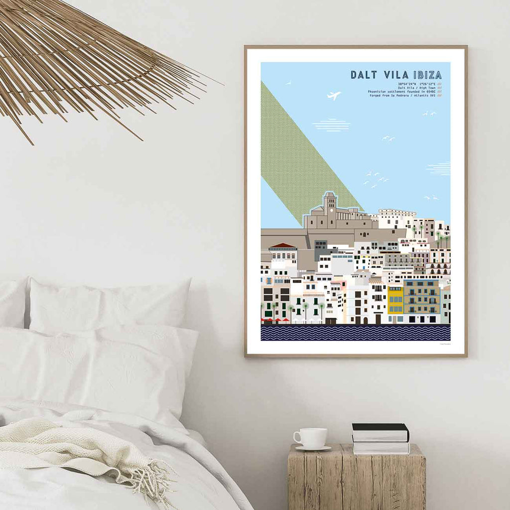 Framed graphic design giclée art print of Dalt Vila, Ibiza pictured in a bedroom.
