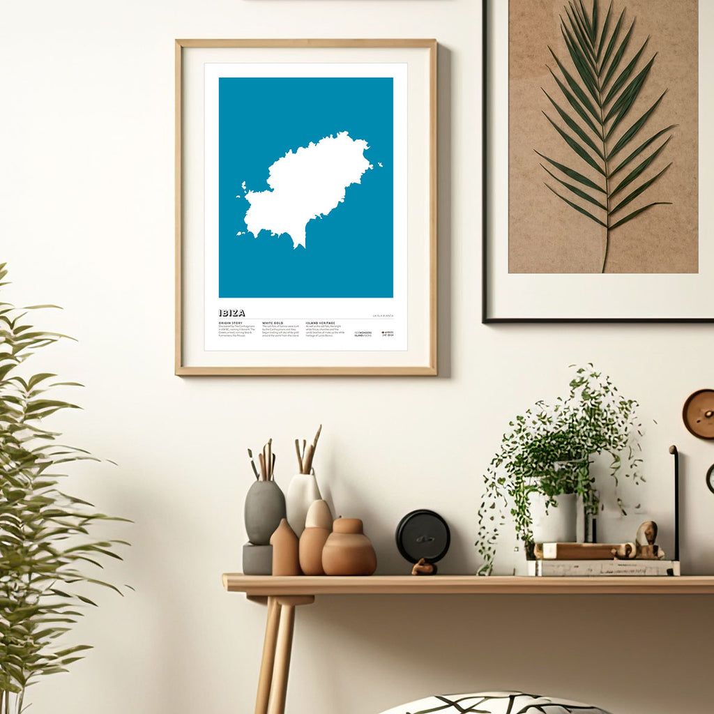 Framed Minimal style graphic design art print of the island of Ibiza from above in white with a rich blue background. 